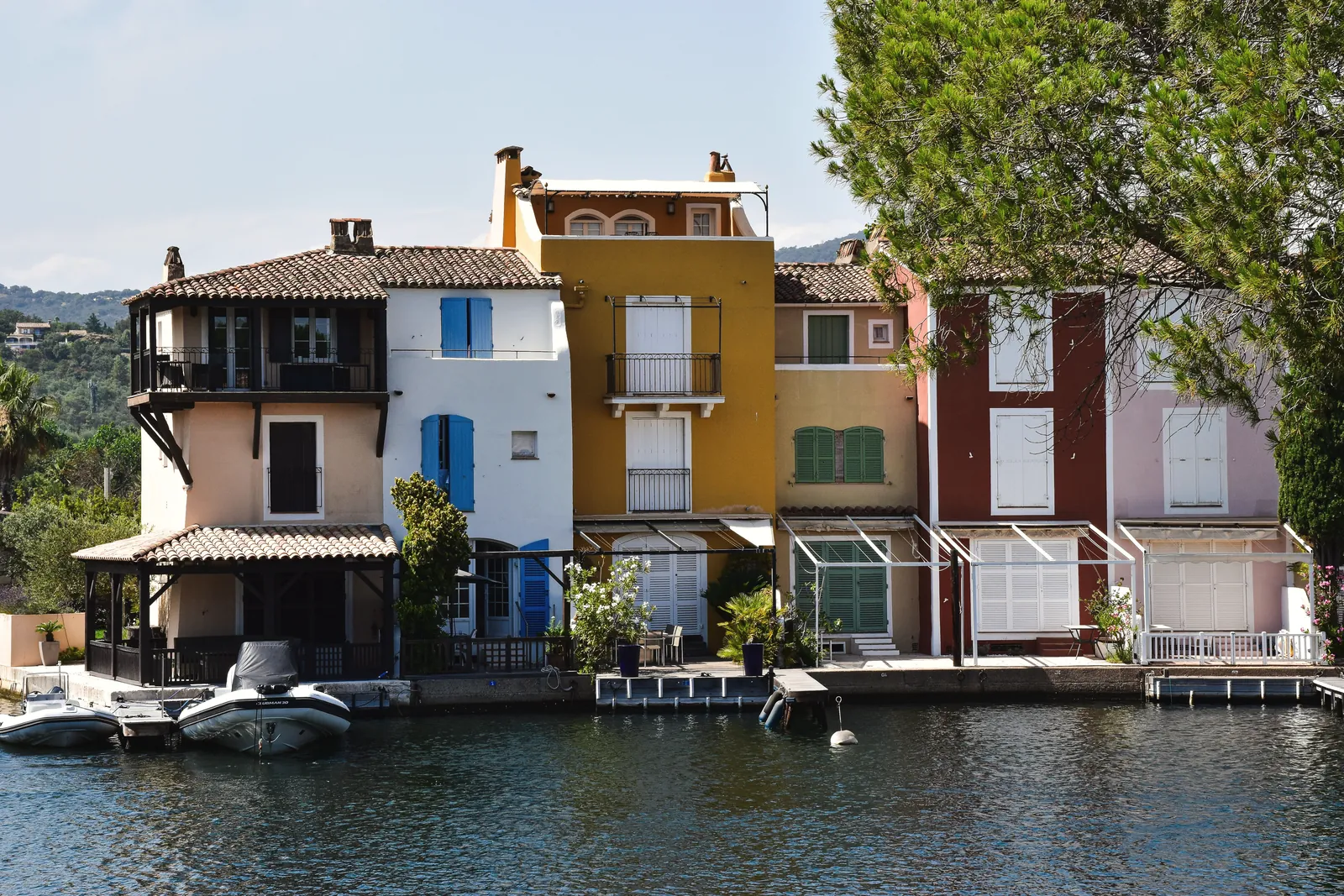 Charming colorful houses by a canal in Provence, showcasing vibrant Mediterranean architecture.