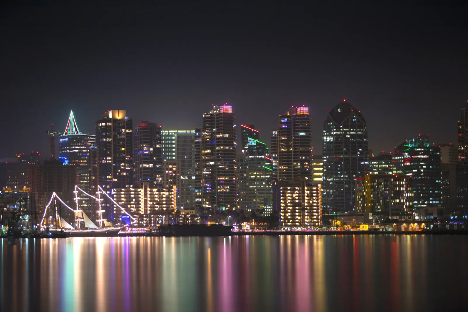 Stunning view of San Diego's illuminated skyline reflecting in calm waters at night.