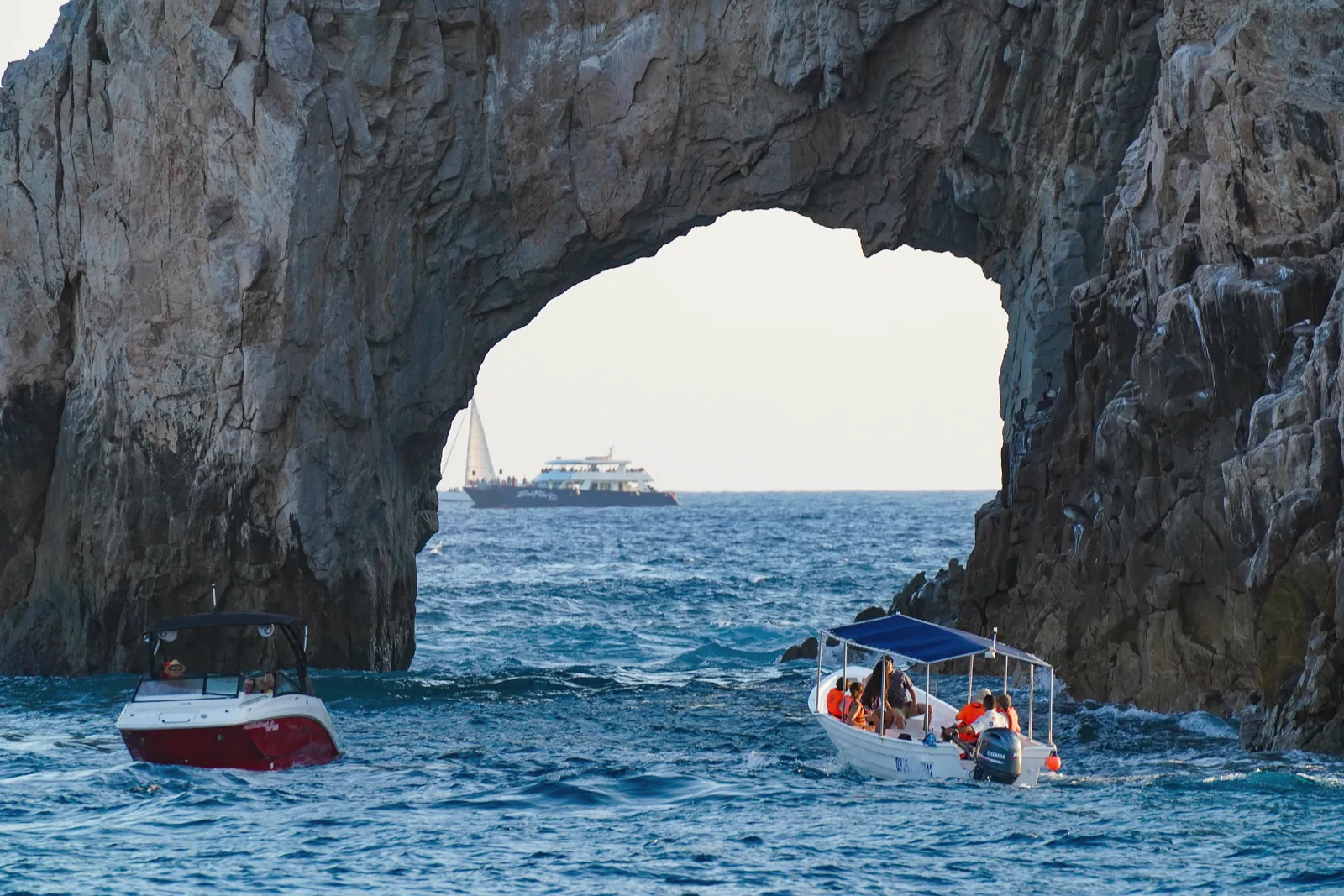 Scenic view of Arch of Cabo San Lucas with boats navigating the ocean waters.