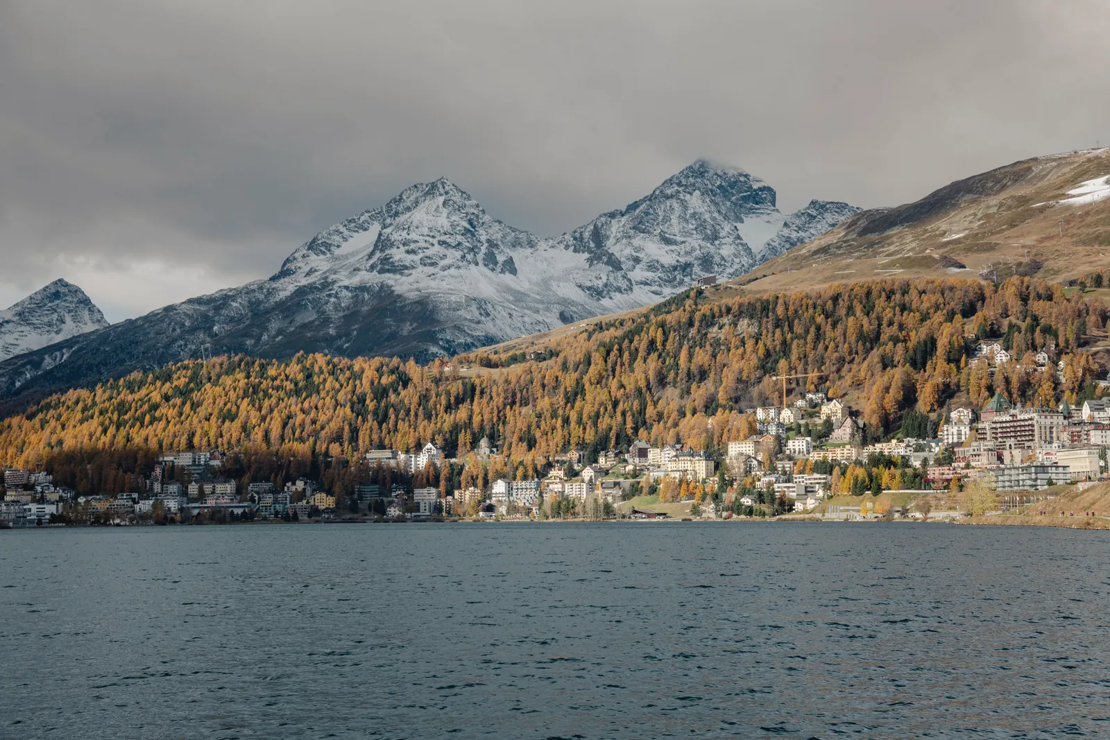 Breathtaking view of Graubünden's alpine landscape featuring snow-capped mountains and vibrant autumn foliage.