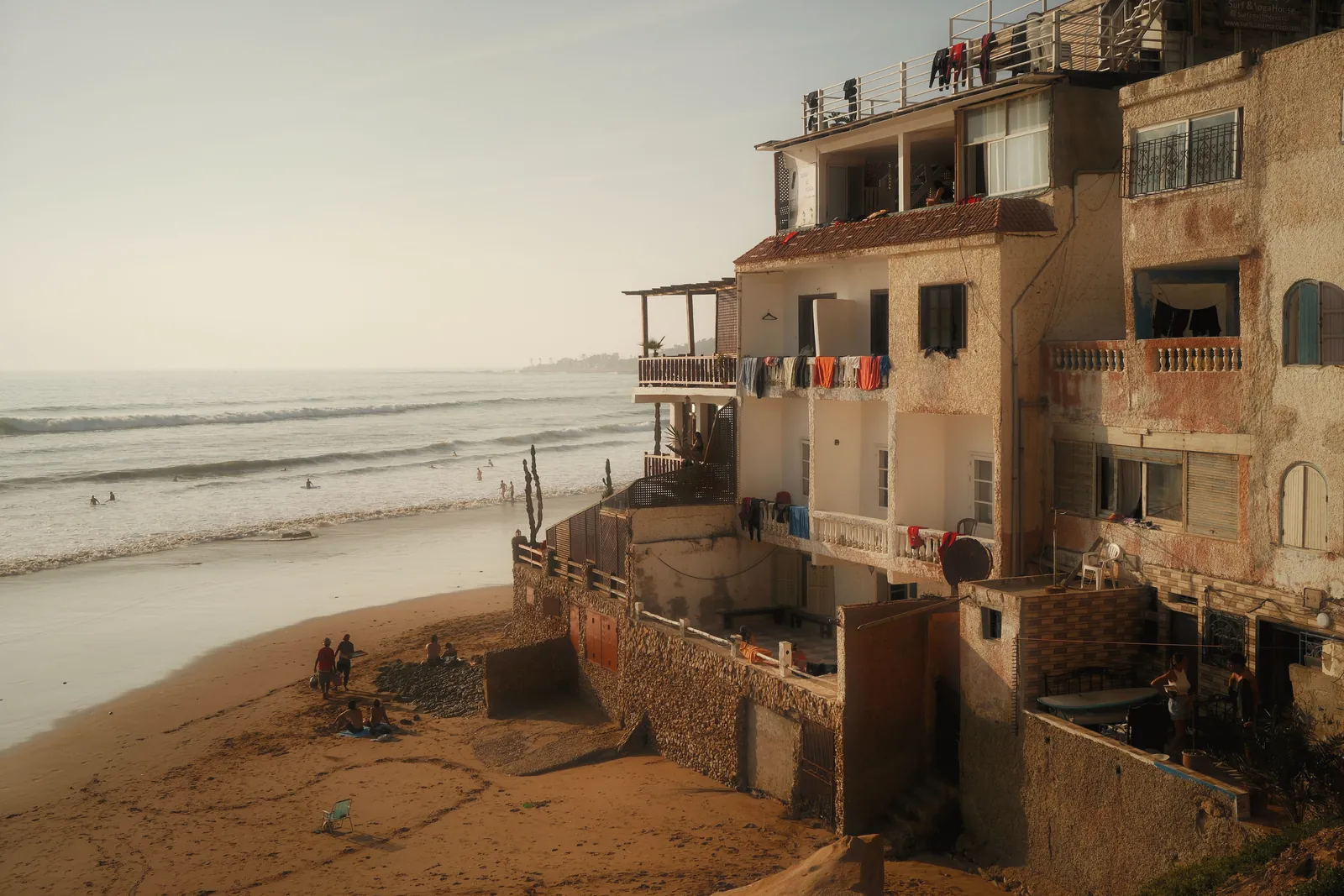 Charming Moroccan coastal scene with traditional architecture and beachgoers.