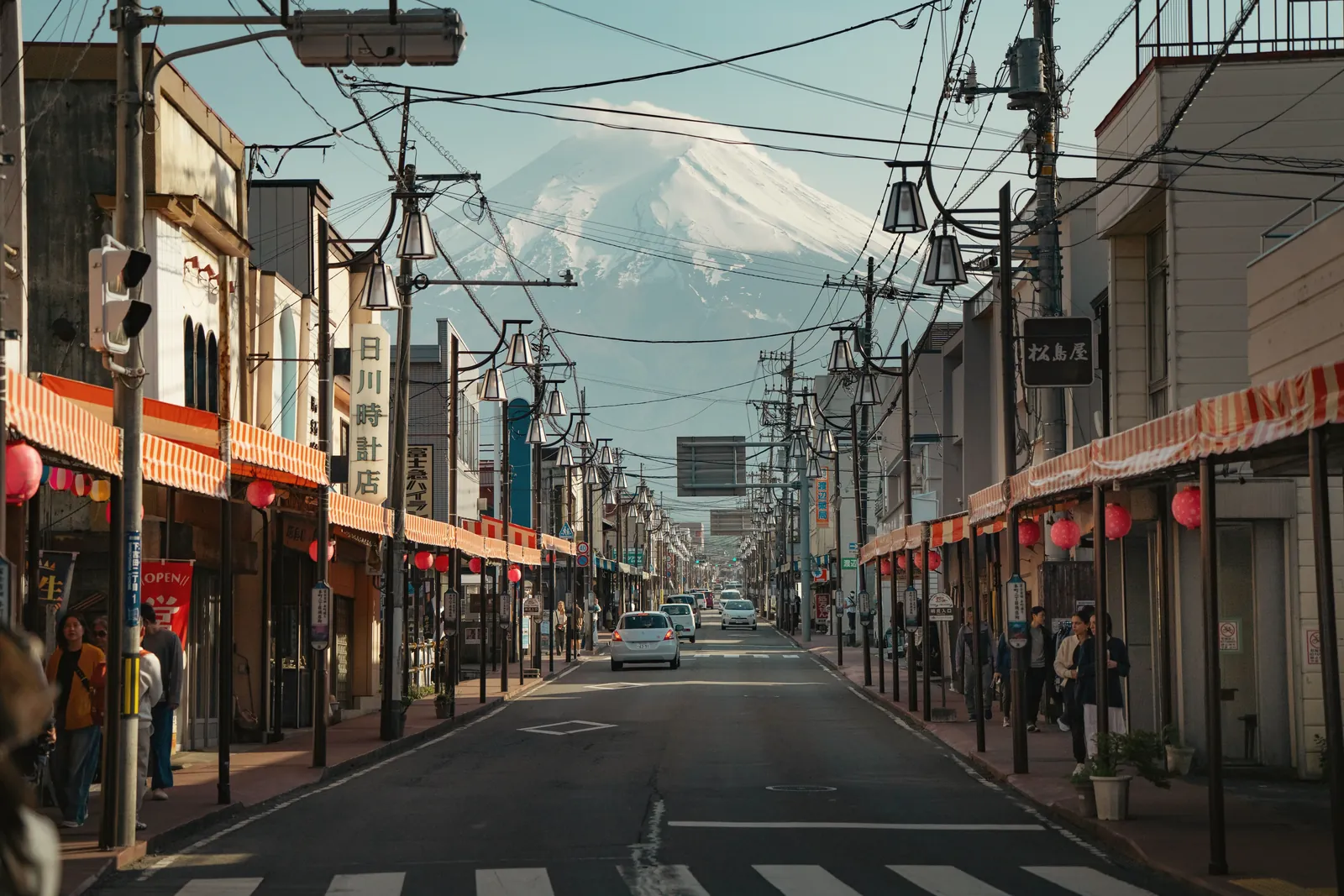 A vibrant street in Japan with Mount Fuji in the background, showcasing daily city life.