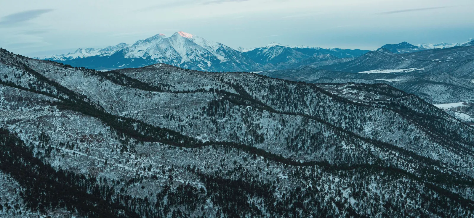 Breathtaking aerial shot of snow-capped mountains in Glenwood Springs, Colorado at dawn.