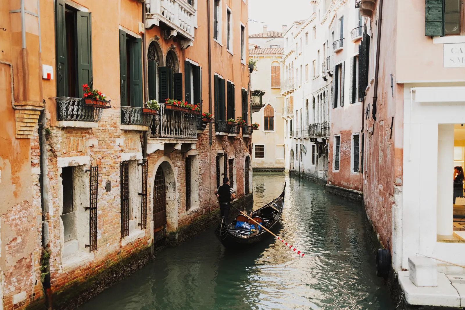 Picturesque view of a gondola on a narrow canal in Venice, Italy, surrounded by charming buildings.