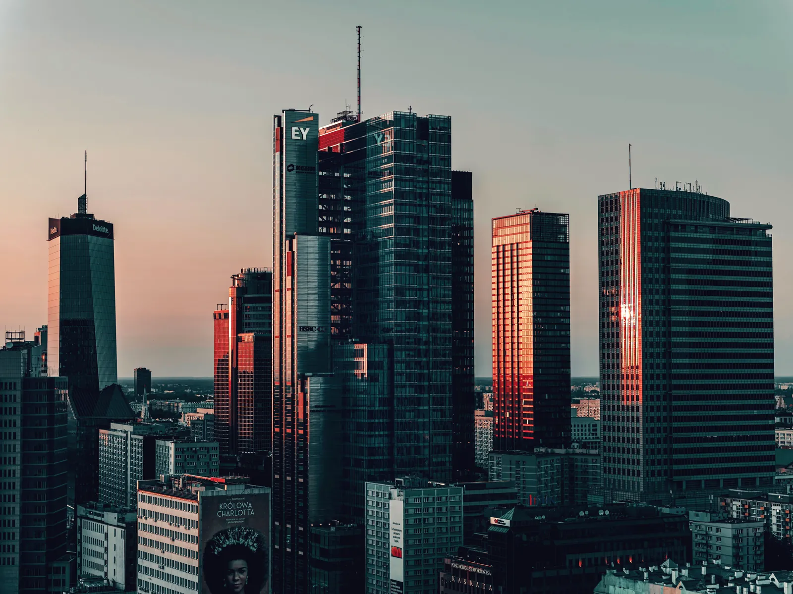 A stunning view of Warsaw's modern office buildings at sunset, showcasing city life and architecture.