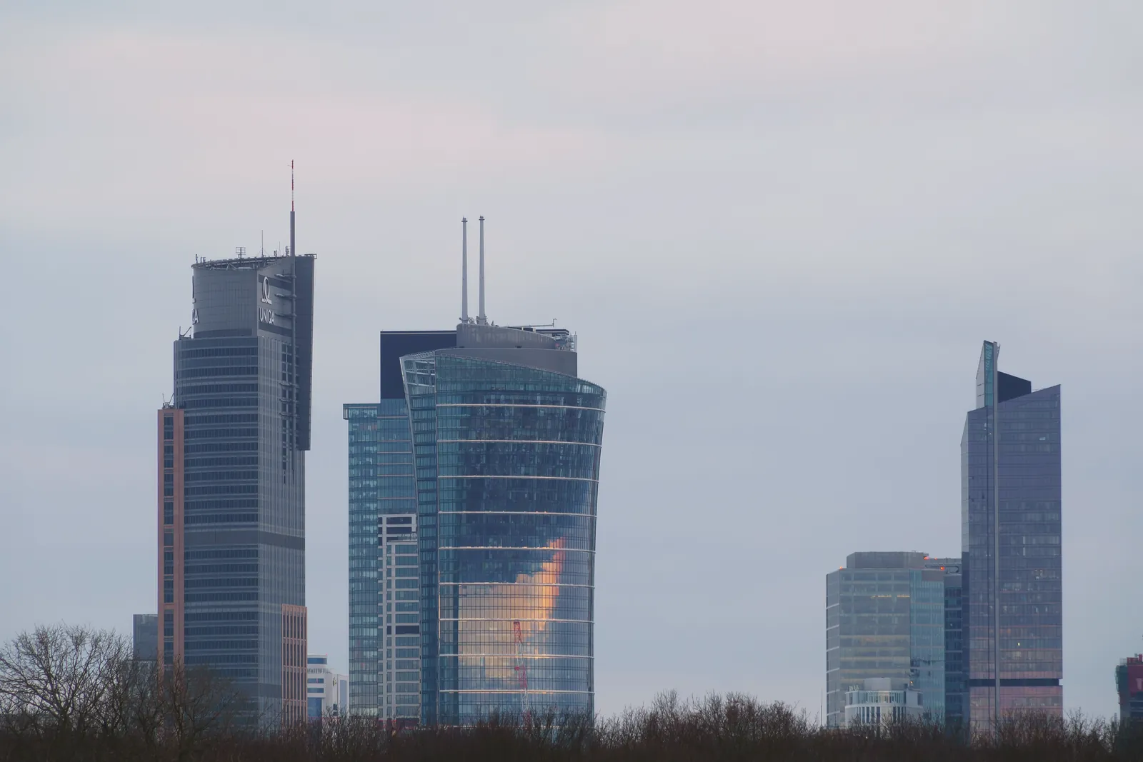 Modern skyscrapers dominate the Warsaw skyline. Twilight view offers a serene cityscape.