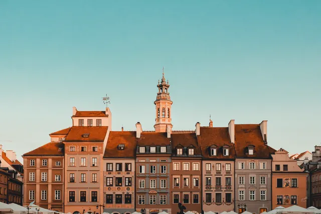 Picturesque view of historic old town buildings and tower in Warsaw under clear sky.