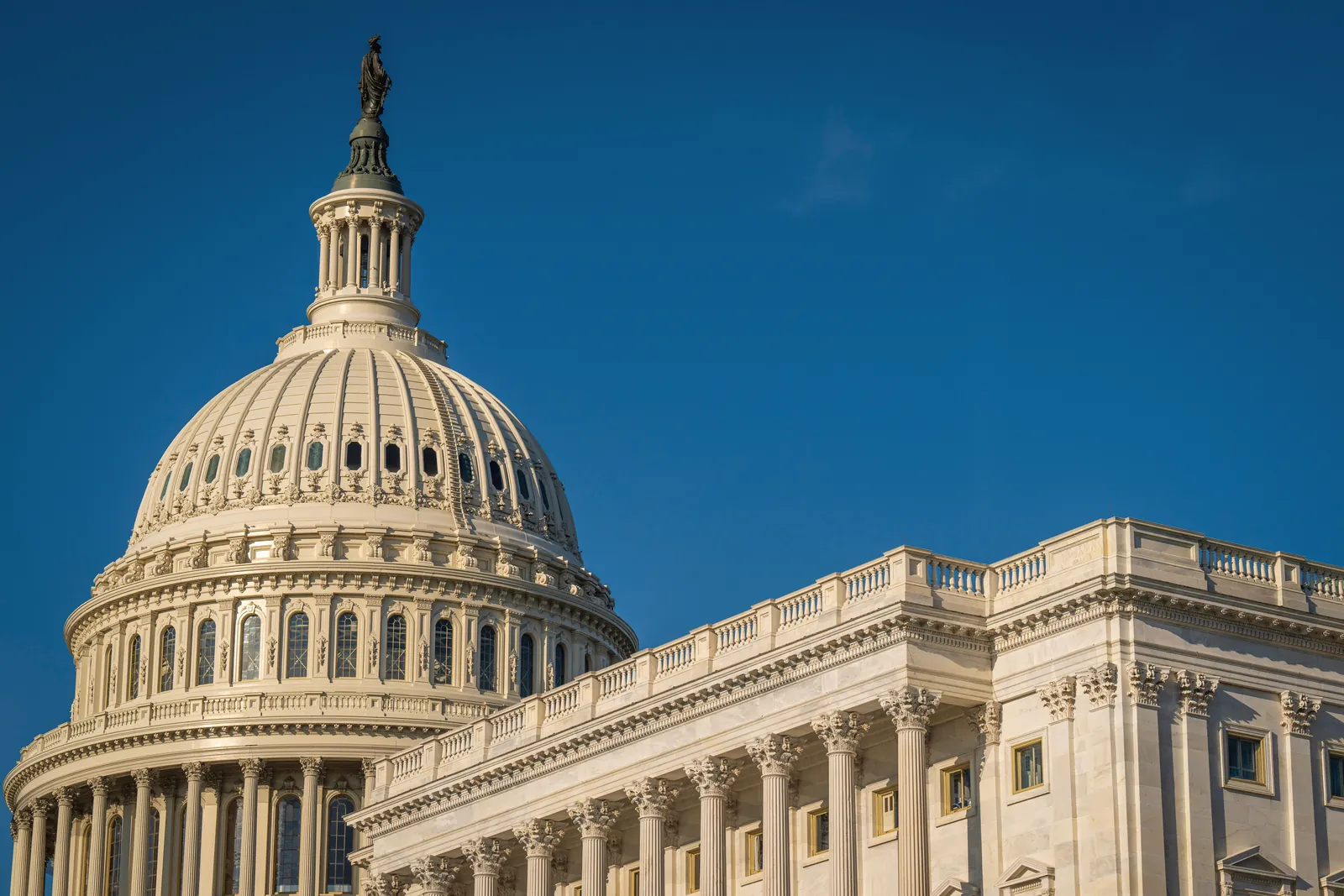 The iconic dome of the United States Capitol against a clear blue sky, showcasing its classical architecture.